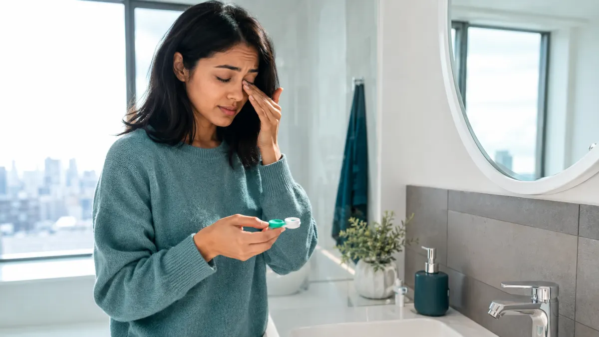 North York contact-lens wearer holding a lens case while experiencing mild eye irritation